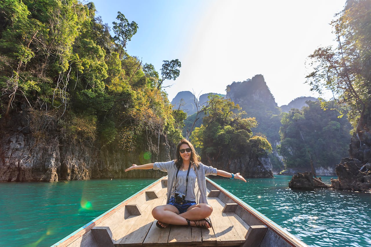 gallery-3 Asian woman relishing a serene boat journey through the lush karst landscape of Thailand's Khlong Sok.